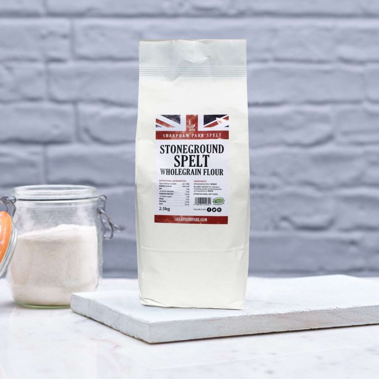 Photo showing the Sharpham Park Non Organic Wholegrain Spelt Flour bag on a white surface with a gla