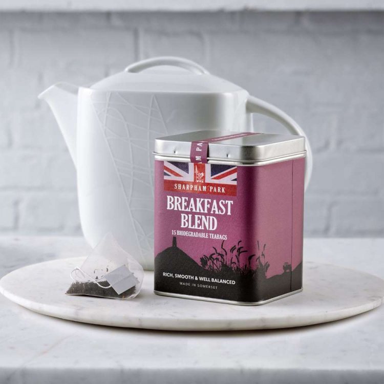Photo showing the Sharpham Park Breakfast Blend Tea Bags box on a white surface with a white teapot 