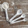 Photo showing the Garden Trading Rialto Measuring Spoons on a wooden surface with flour dusted over 